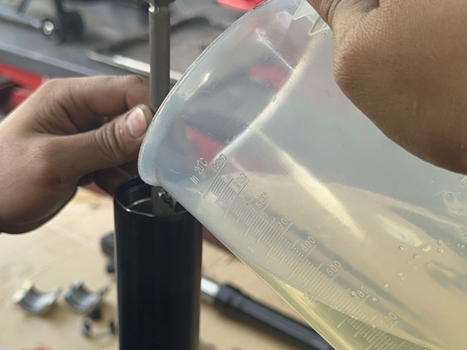 MotoNorte technician refilling fork oil during a suspension service