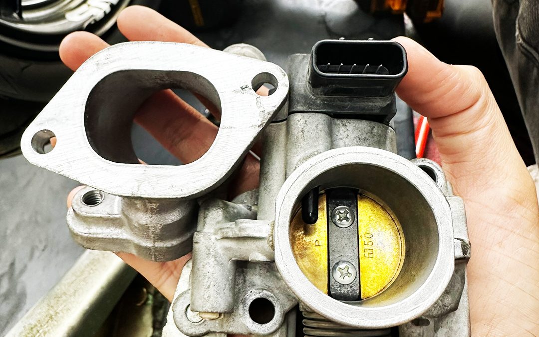 Technician holding a motorcycle throttle body