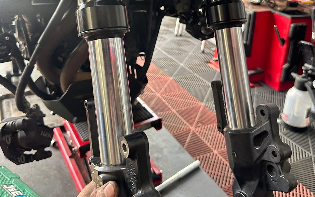Front forks of a motorcycle on a red lift for suspension service