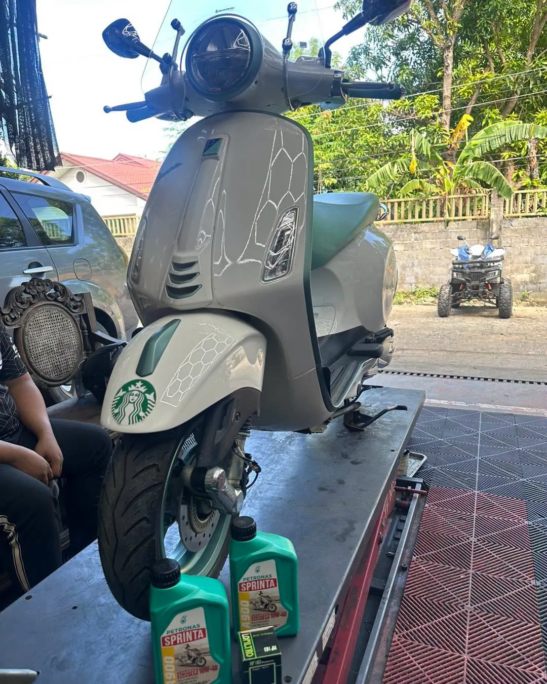 Vespa on the service lift at MotoNorte with Petronas Sprinta oil