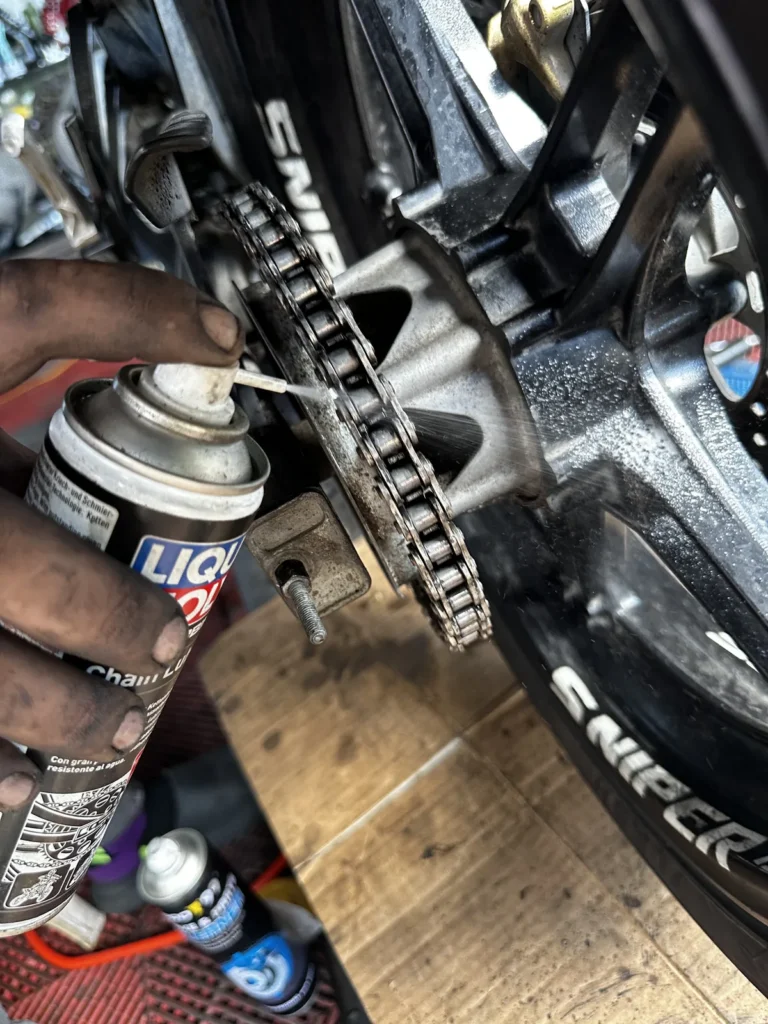 Chain lube being applied to a Yamaha Sniper chain at MotoNorte