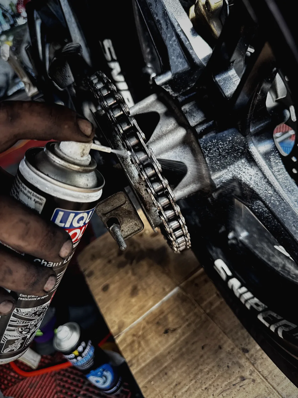 Chain lube being applied to a Yamaha Sniper chain at MotoNorte