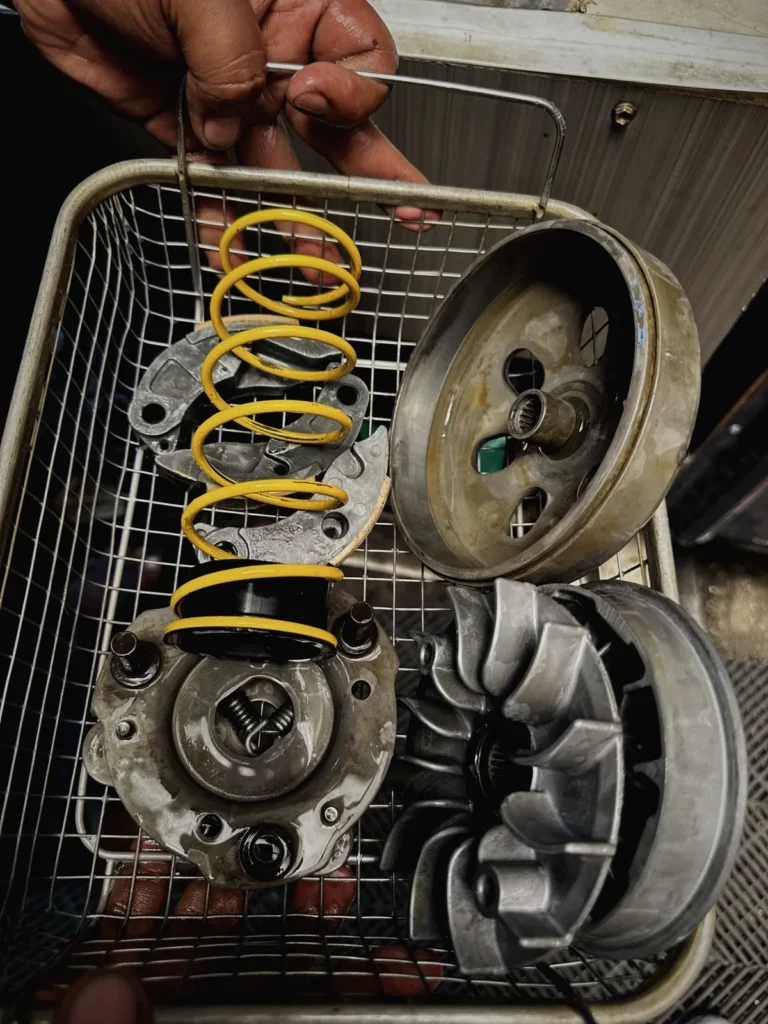 Cleaned CVT pulley, clutch and spring in a parts basket at MotoNorte