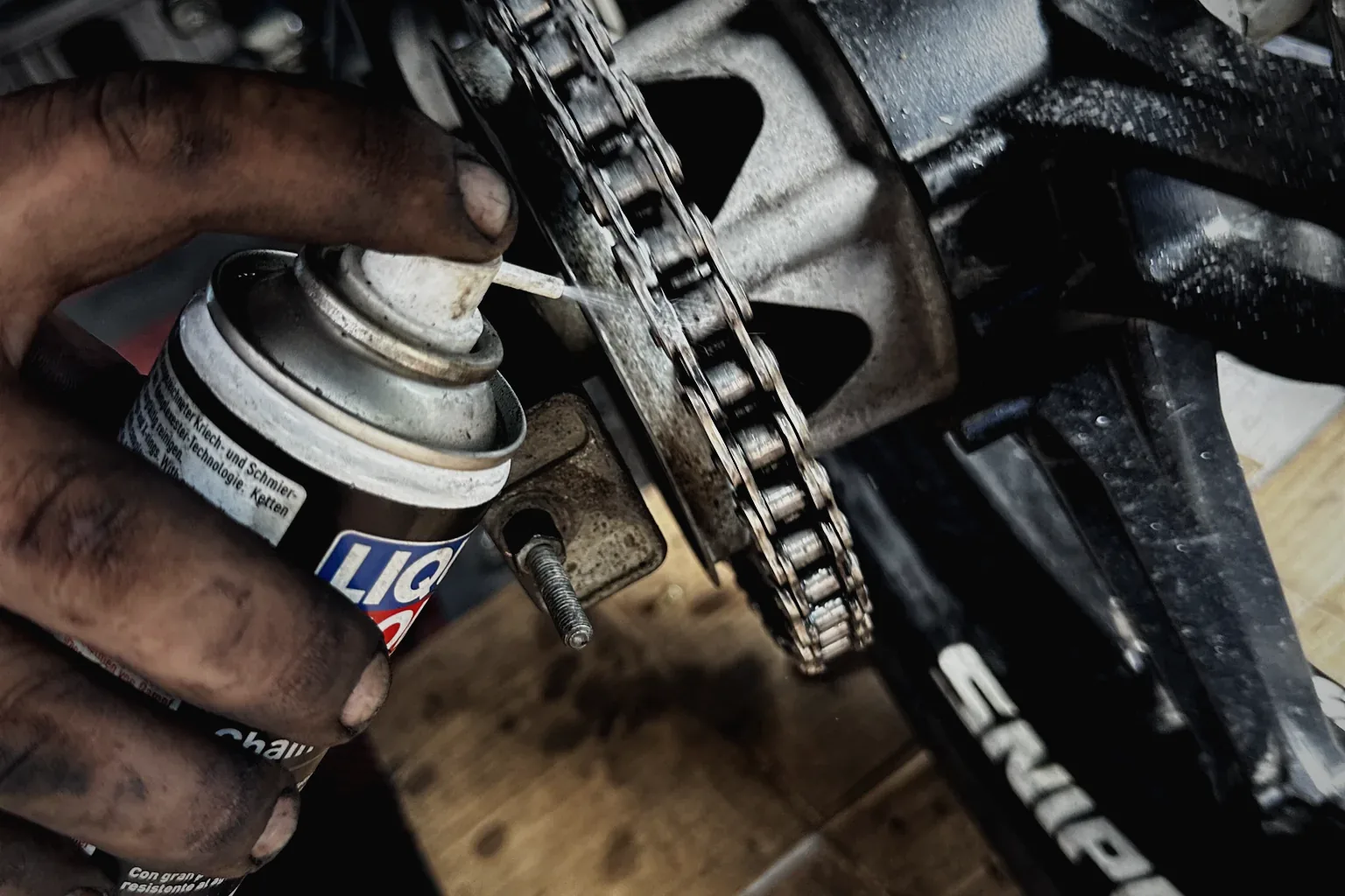 Liqui Moly chain lube being applied to a motorcycle chain at MotoNorte