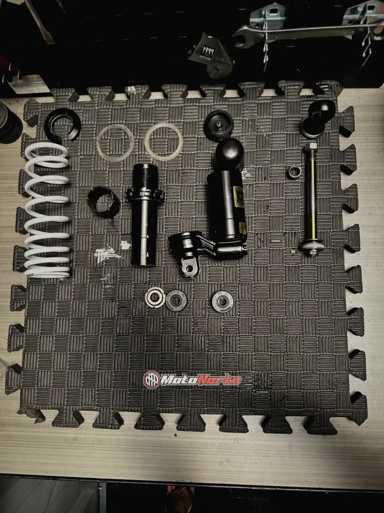Rear shock absorber parts laid out for a rebuild at MotoNorte