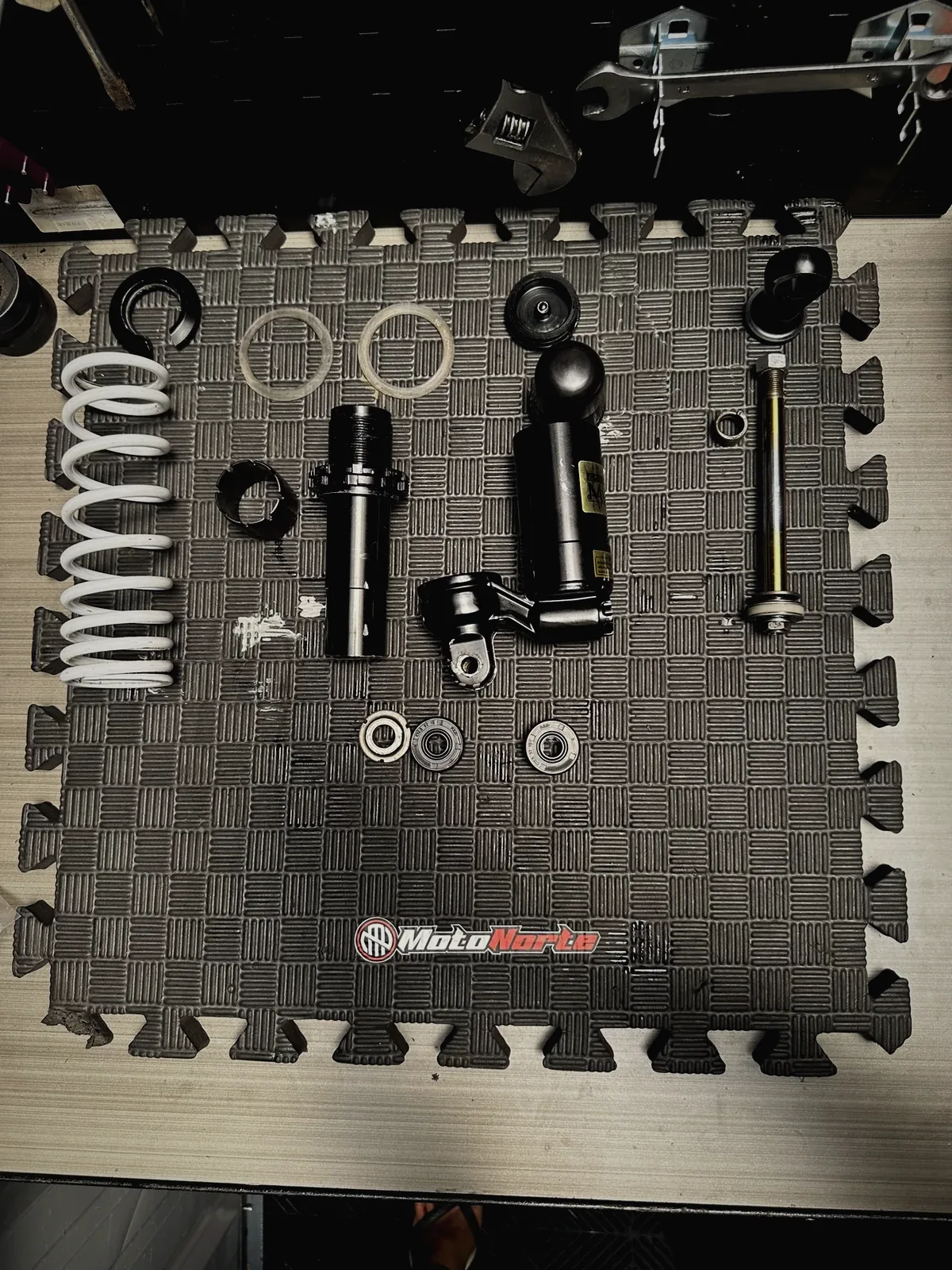 Rear shock absorber parts laid out for a rebuild at MotoNorte