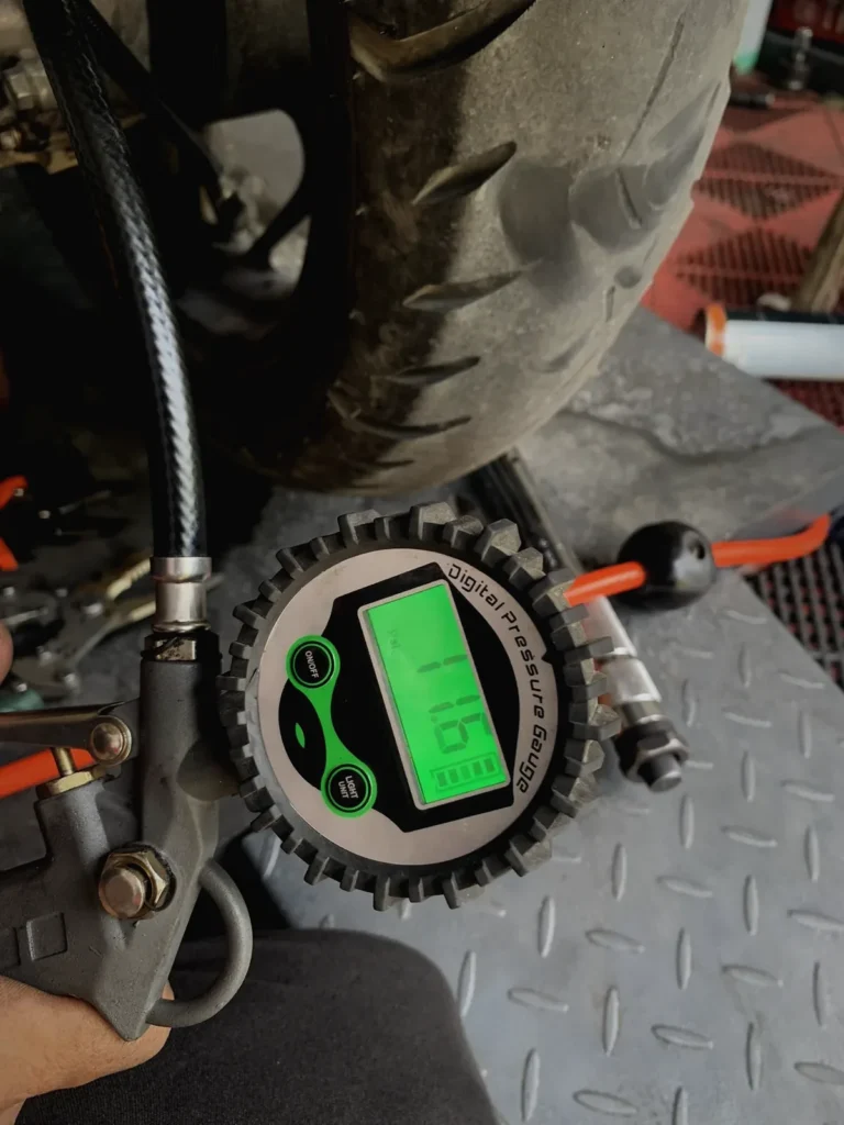 Checking motorcycle tire pressure with a digital gauge at MotoNorte, Batac City
